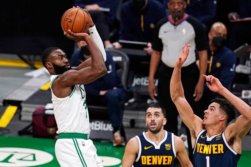 Boston Celtics guard Jaylen Brown, left, shoots over Denver Nuggets forward Michael Porter Jr. (1) and guard Facundo Campazzo, center, during the second half, Tuesday, Feb. 16, 2021, in Boston.