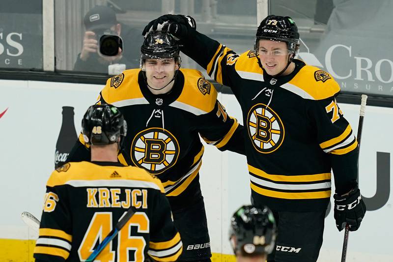 Boston Bruins left wing Jake DeBrusk (74) celebrates his goal with Charlie McAvoy (73) and David Krejci during the second period of the team's NHL hockey game against the New York Rangers, Thursday, March 11, 2021, in Boston.