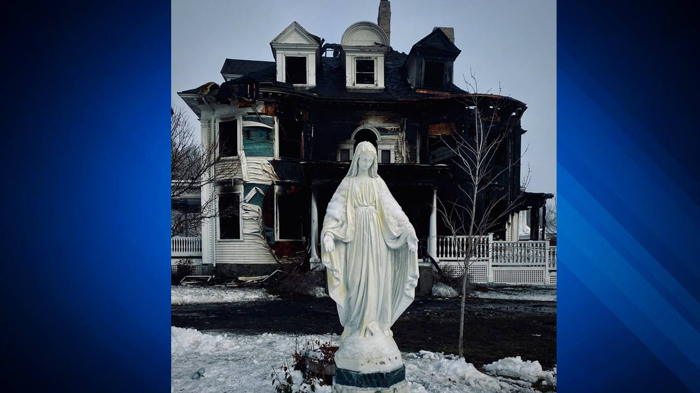 A statue of Mary in front of the burned-out rectory of  St. John the Evangelist church in Townsend on Monday, Dec. 21.