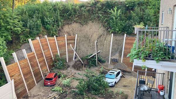 Cars buried under mud after retaining wall collapses at Brighton condo complex 