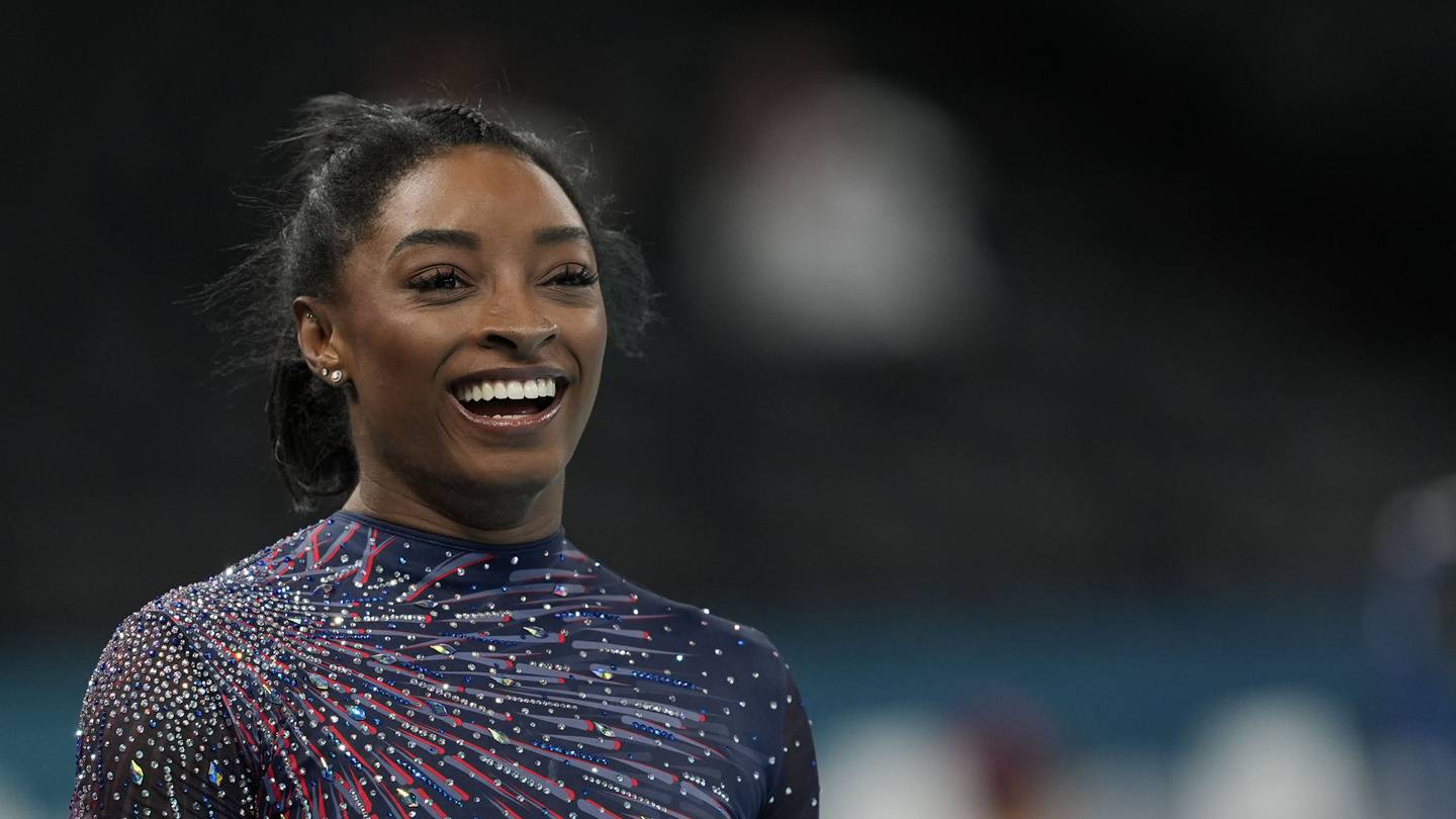 Simone Biles is on the Olympic gymnastics competition floor in front of