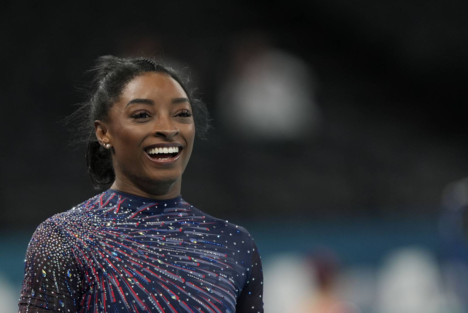 Simone Biles is on the Olympic gymnastics competition floor in front of