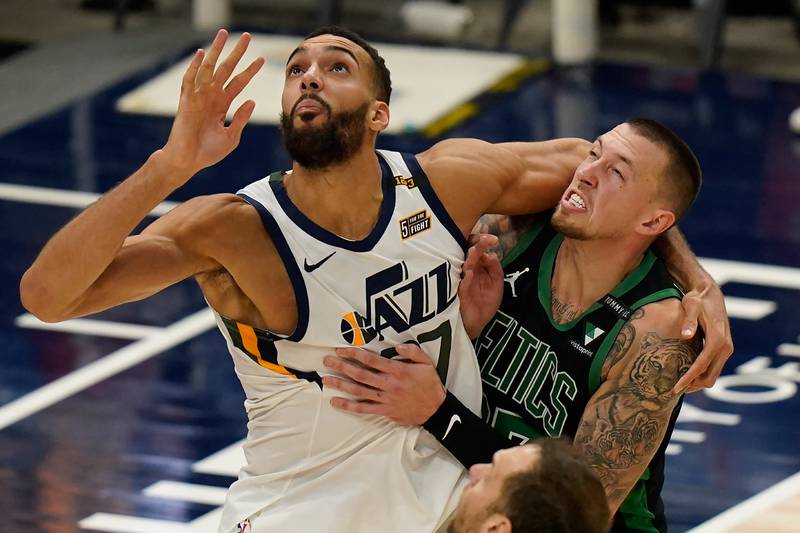 Utah Jazz center Rudy Gobert, left, and Boston Celtics center Daniel Theis, right, battle for position under the boards in the second half, Tuesday, Feb. 9, 2021, in Salt Lake City.