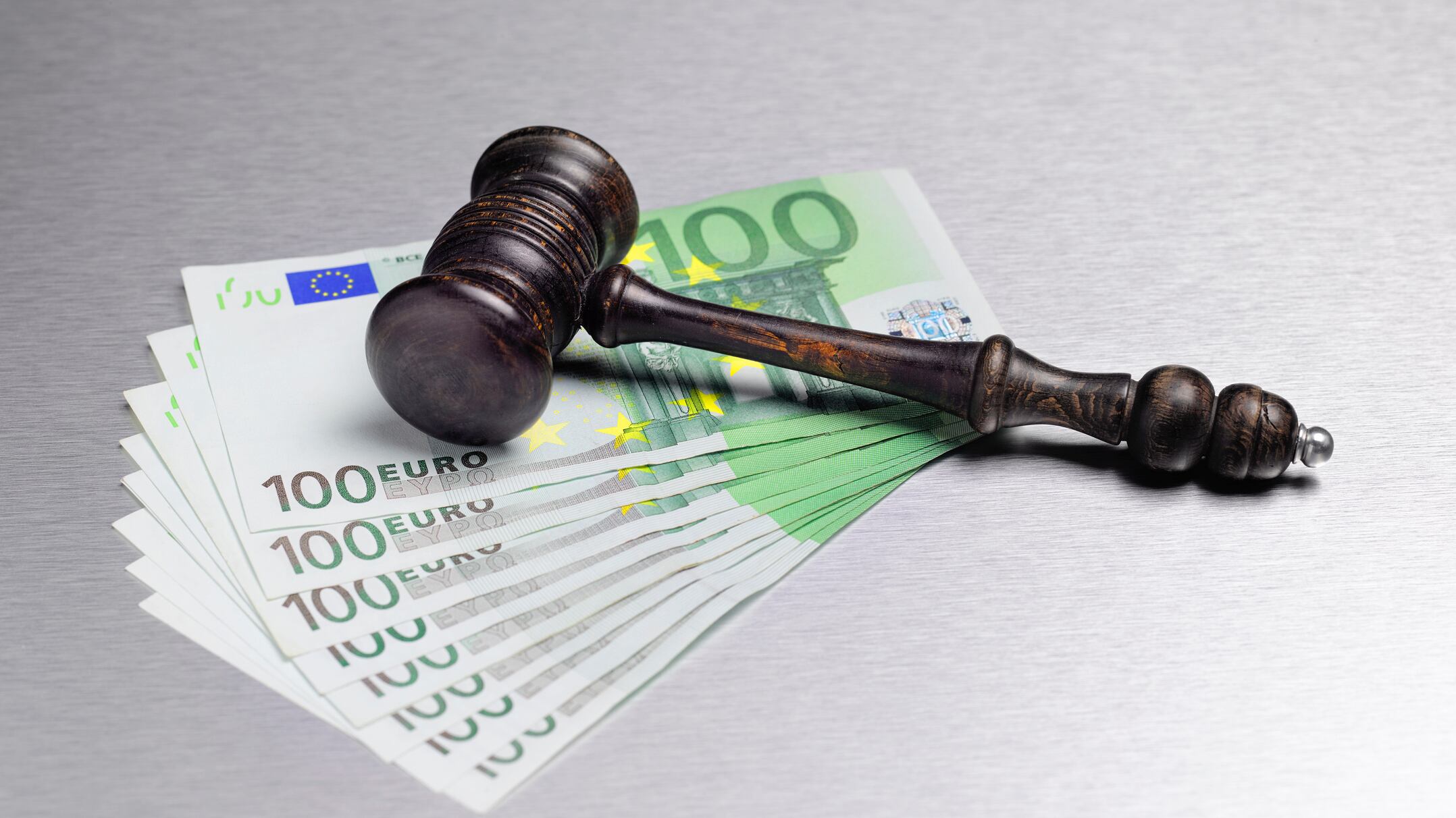 gavel laying on 100 euro bills.