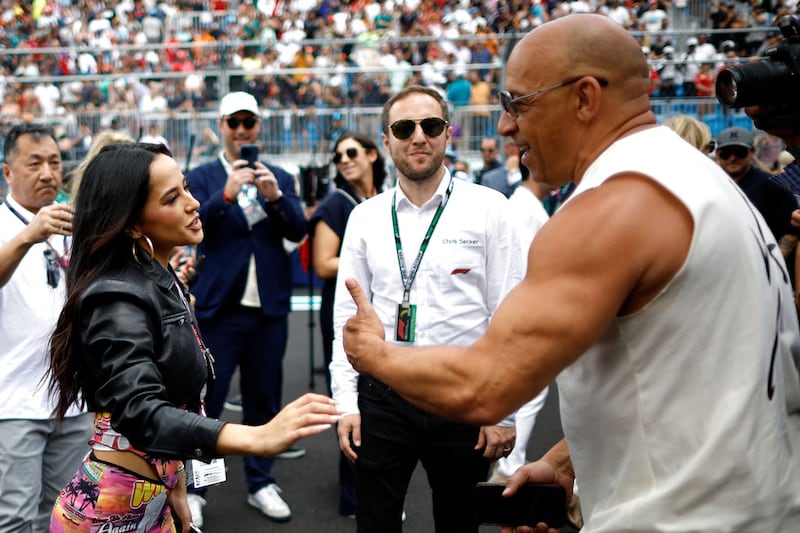 MIAMI, FLORIDA - MAY 07: Vin Diesel talks with Becky G on the grid prior to the F1 Grand Prix of Miami at Miami International Autodrome on May 07, 2023 in Miami, Florida. (Photo by Chris Graythen/Getty Images)