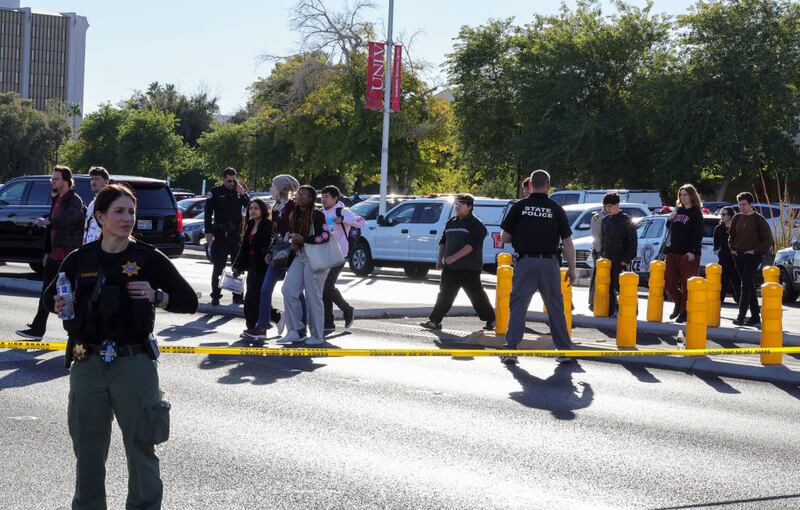 LAS VEGAS, NEVADA - DECEMBER 06: People cross Maryland Parkway as they are led off of the UNLV campus after a shooting on December 06, 2023 in Las Vegas, Nevada. According to Las Vegas Metro Police, a suspect is dead and multiple victims are reported after a shooting on the campus. (Photo by Ethan Miller/Getty Images)