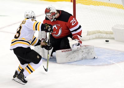 Boston Bruins center Brad Marchand scores a goal past New Jersey Devils goaltender Makenzie Blackwood during the shootout of an NHL hockey game Thursday, Jan. 14, 2021, in Newark, N.J.