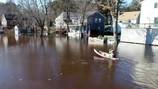 Residents seen in canoes after broken dam causes extensive flooding in East Bridgewater